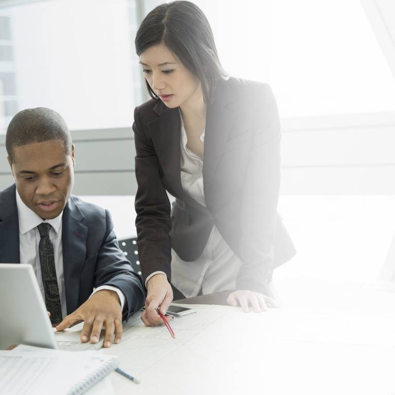 Businessman and businesswoman looking at laptop