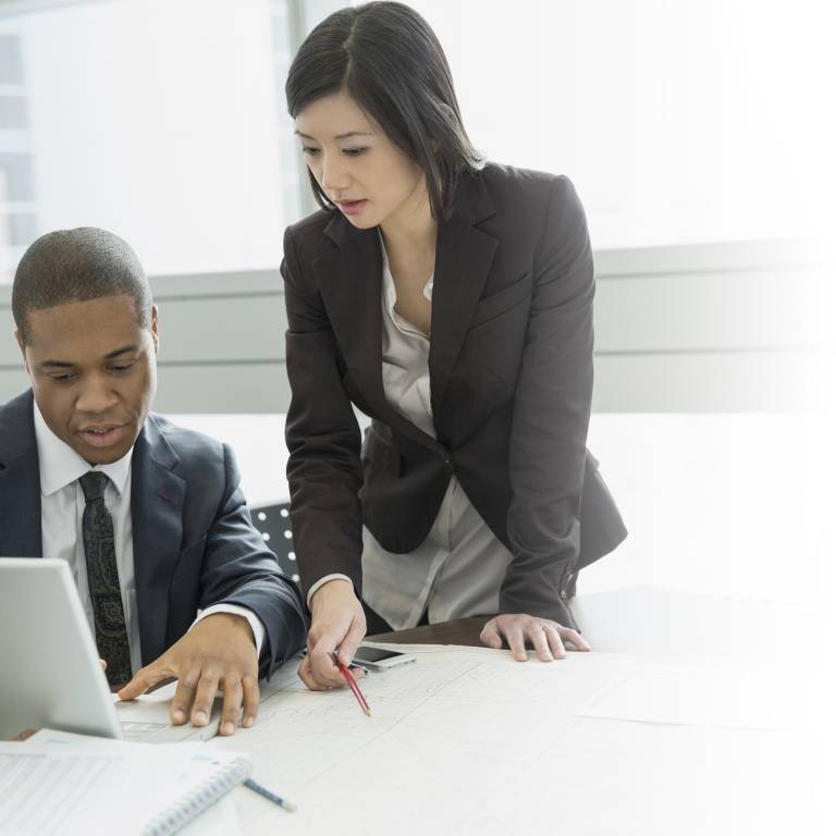 Businessman and businesswoman looking at laptop